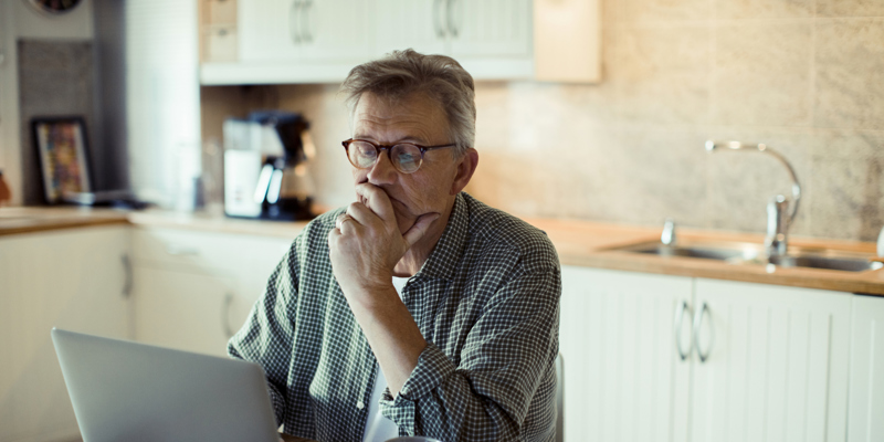 Mand der sidder ved computer og arbejder hjemmefra