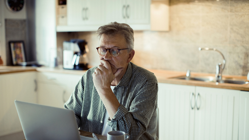 Mand der sidder ved computer og arbejder hjemmefra
