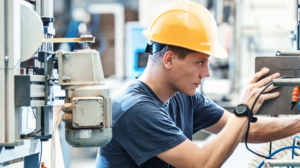 Medarbejder med hjelm på maskinværksted