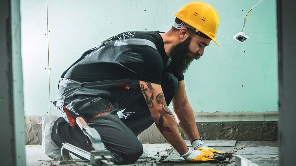 A bricklayer laying tiles