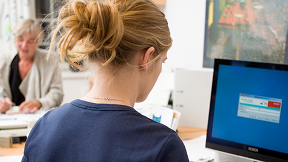 En kvinde der sidder foran computeren på arbejde