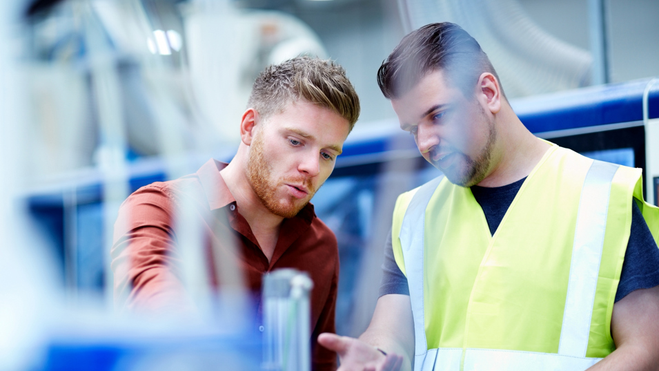 To personer snakker om en arbejdsopgave.