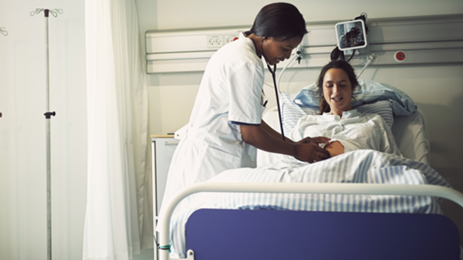 Læge tilser patient i hospitalsseng