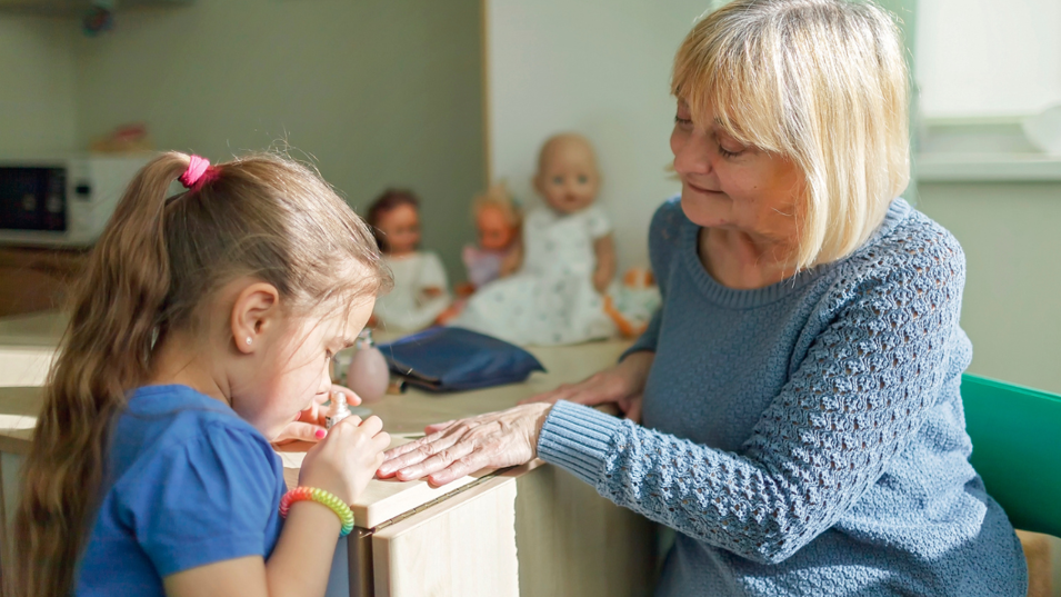 En bedstemor, der får lagt neglelak af en pige