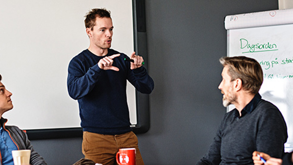 Kolleger der sidder rundt et bord og diskuterer