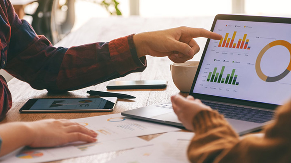 Kolleger der sidder og diskuterer nogle data tabeller