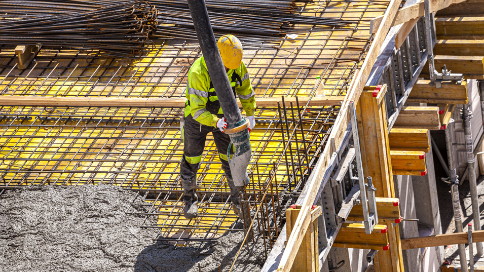 Betonarbejder i færd med at støbe på en større byggeplads.