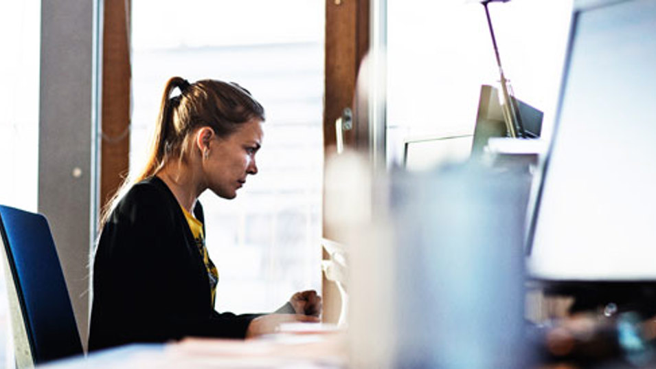 En kvinde der sidder på et kontor og arbejder på en computer