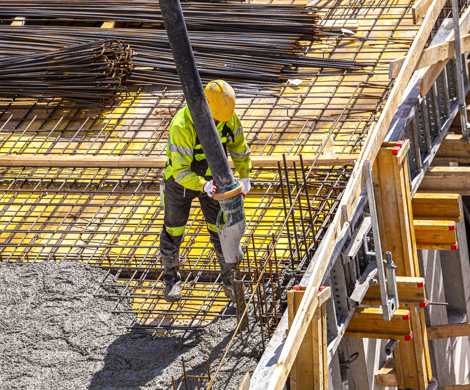 Mand støber i beton på et nybyggeri.