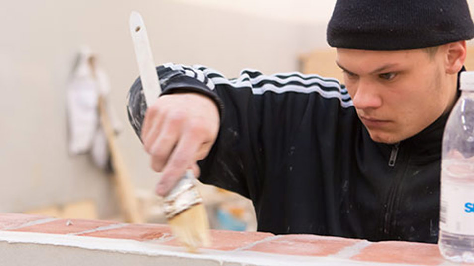 En håndværker der arbejder med en murstensvæg