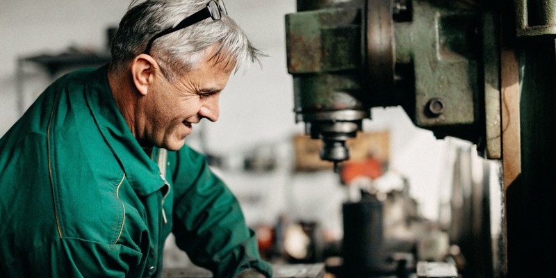 En senior herre, der arbejder på et værksted