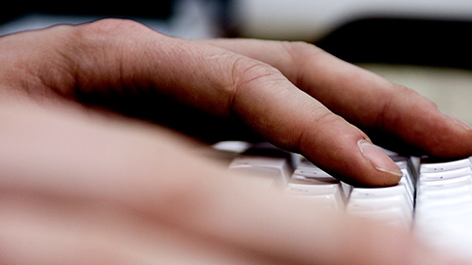 En hånd der hviler på et tastatur