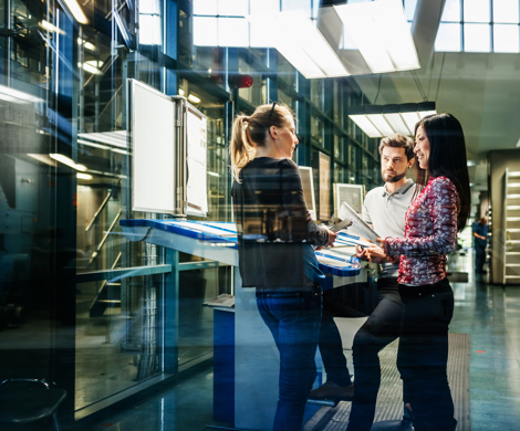 Tre kolleger der er i færd med at planlægge nogle arbejdsopgaver