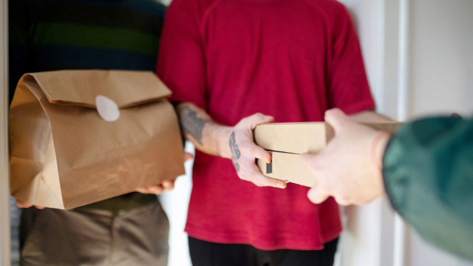 To fyre tager imod en madlevering fra et bud.