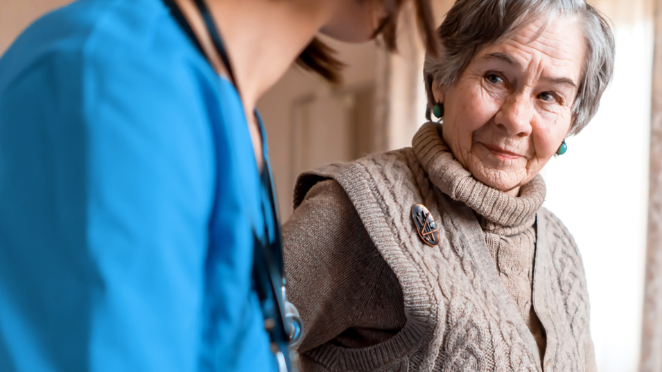 En ældre borger, som sidder sammen med en fra hjemmeplejen