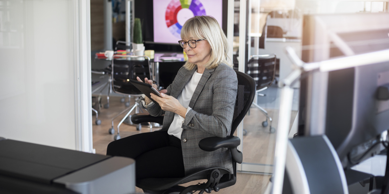 Kvindelig senior der sidder på kontoret og arbejder