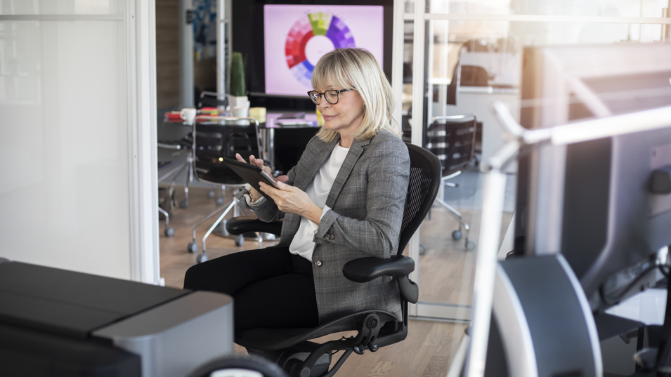 Kvindelig senior der sidder på kontoret og arbejder