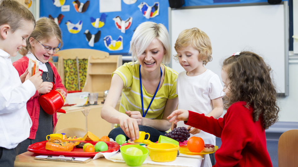 Pædagog der er i fuld gang med at lege med nogle børn